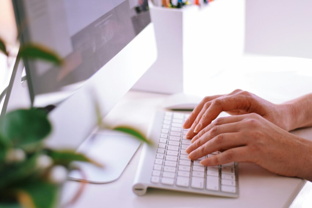 Woman is sitting at a desk and working on a computer